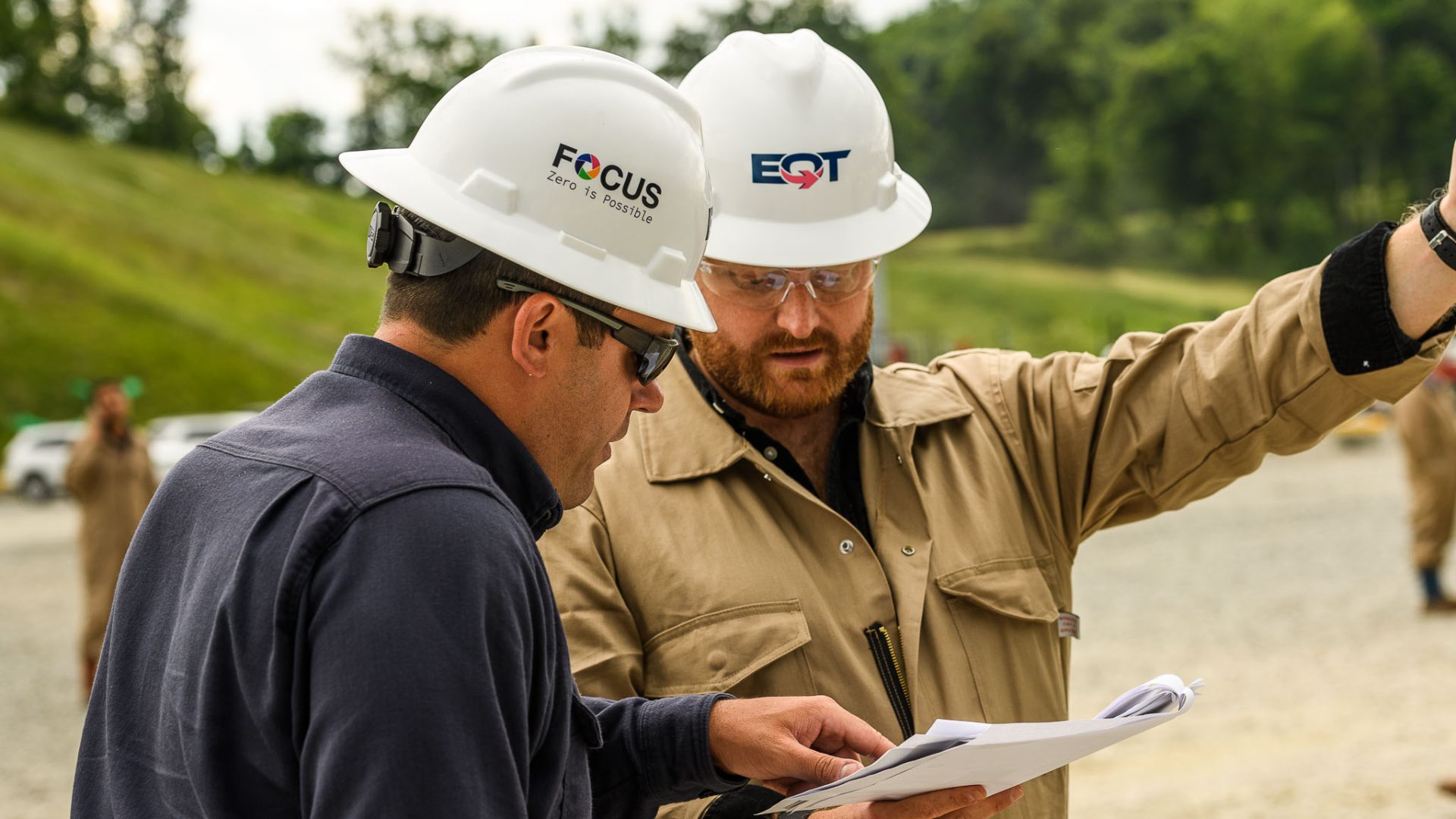 EQT employees in the field looking at a piece of paper