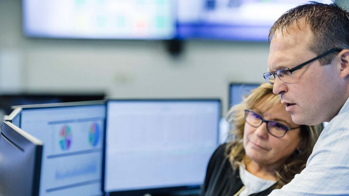 Two people in an office working together on a computer